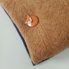 broche renard endormi en argile polymère présentée sur un pull